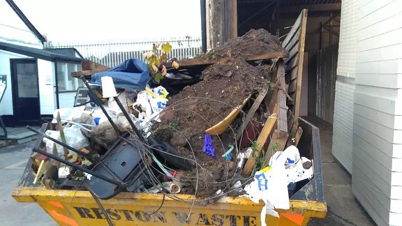 Skip dangerously overloaded with rubbish